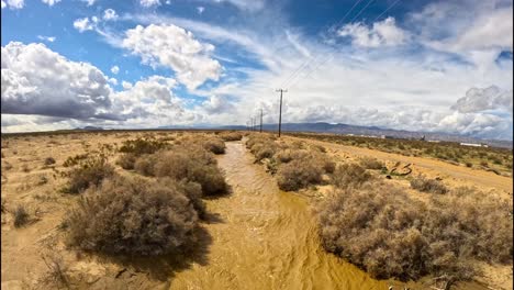vuelo rápido sobre las aguas de caché creek en el desierto de mojave después de una tormenta