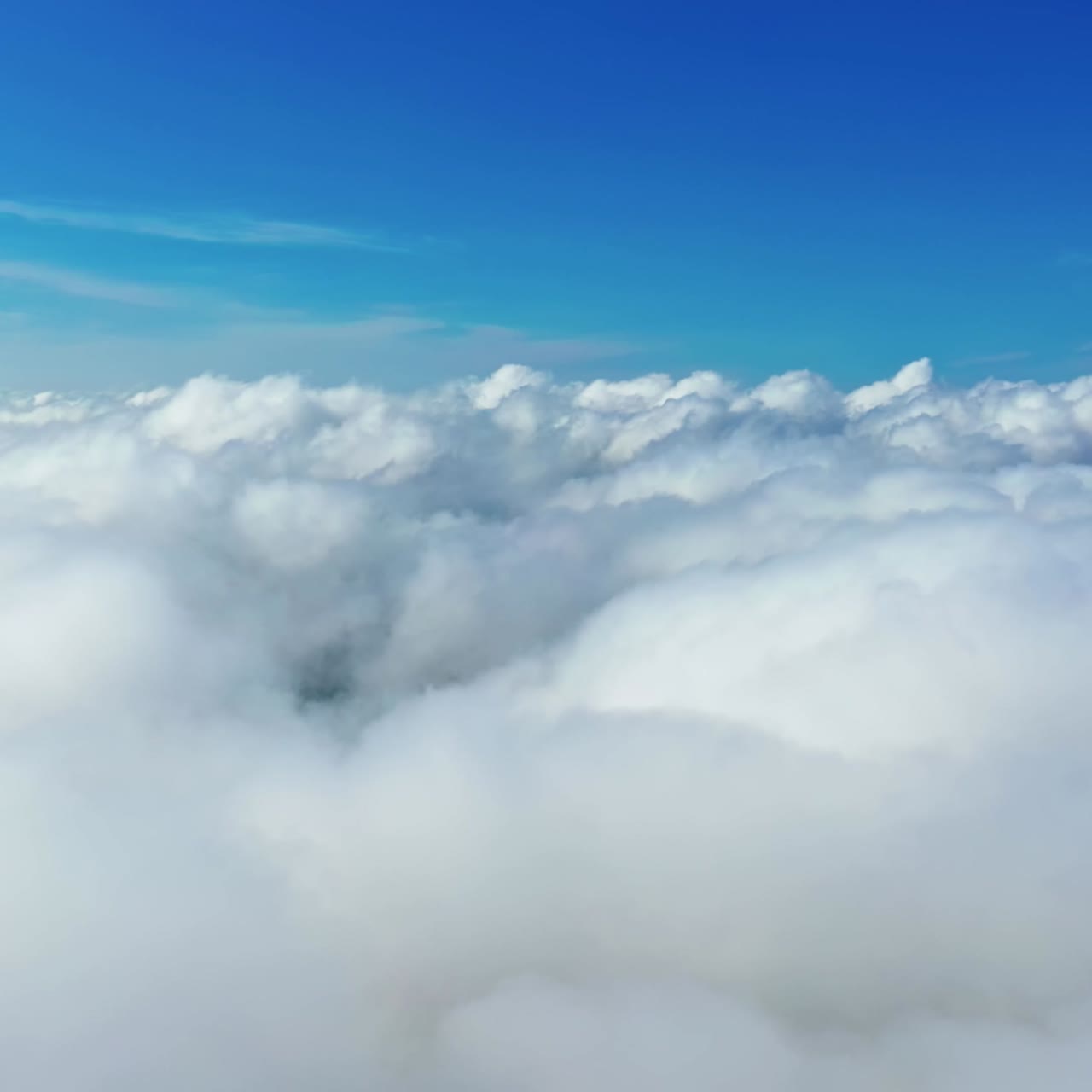 Beautiful white clouds in the air. Panoramic view of blue sky with soft clouds background. Amazing cloudscape. Aerial view.