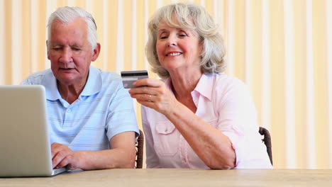 senior couple paying their bills with laptop