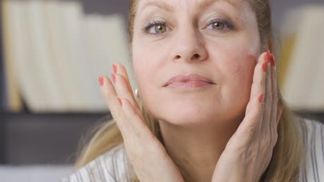 la anciana mira su rostro arrugado y está satisfecha.