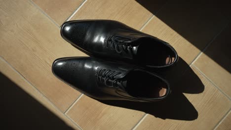 Black-dress-shoes-in-sunlight,-light-and-shadow-play