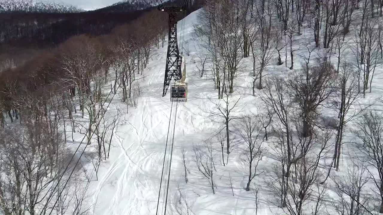 공중 - 눈 덮인 산을 여행하는 스키 곤돌라의 드론 샷