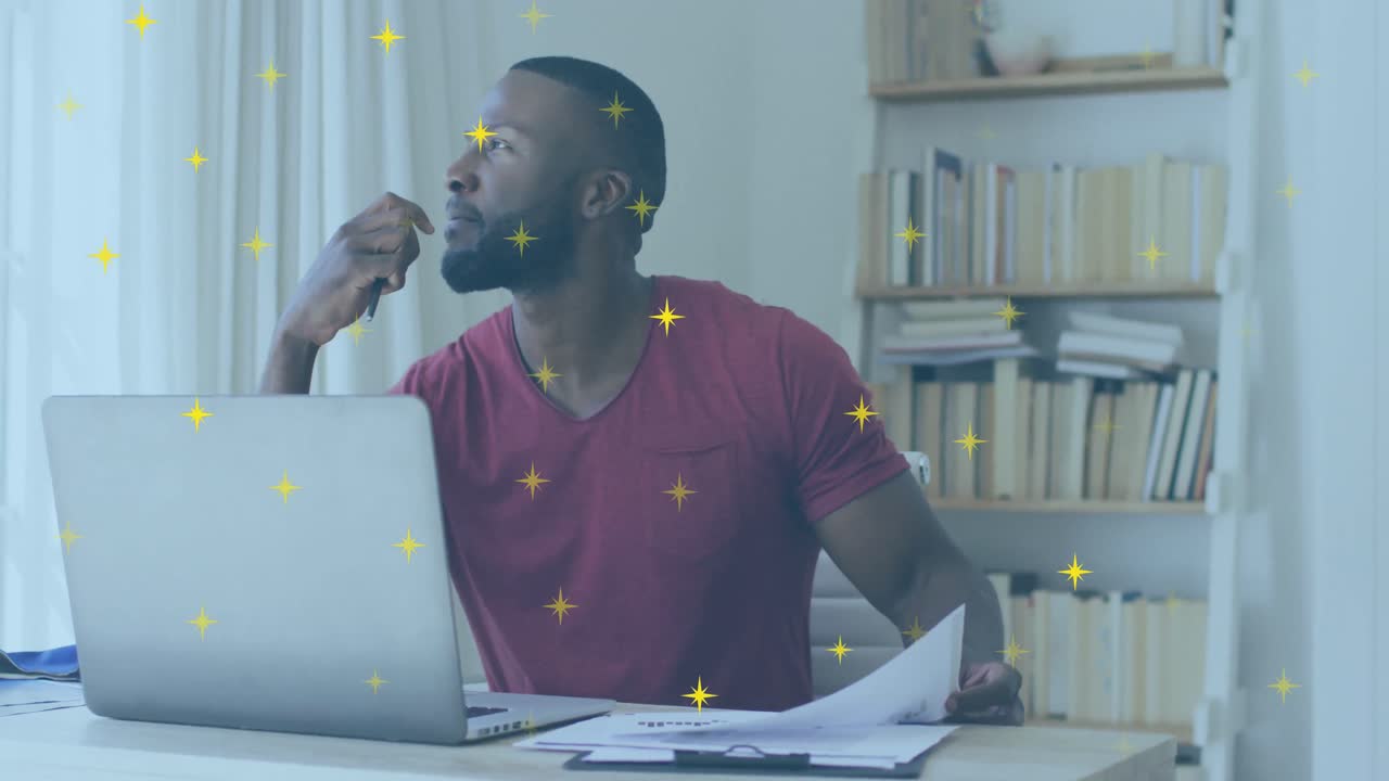 Animation of shining star icons over african american man holding a document using laptop