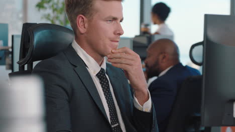 attractive businessman using computer in busy office executive working on company project deadline