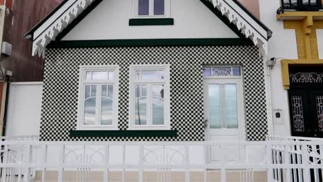 Beautiful-small-palheiro-with-white-and-green-squares-by-Costa-Nova-beach-in-Aveiro,-Portugal