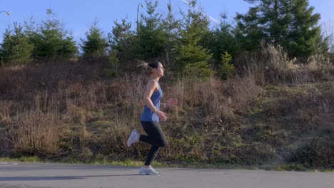 fit woman out running along road tracking shot