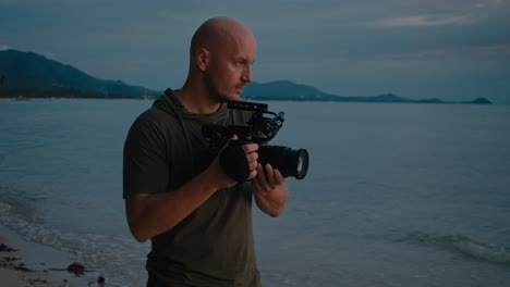 videographer filming on the beach at sunset