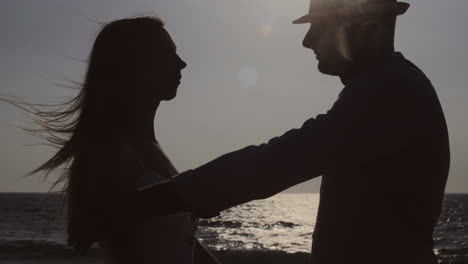 young couple hugging and kissing at seaside