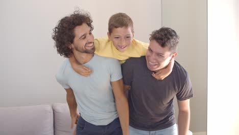 niño alegre y sus dos padres disfrutando de la actividad doméstica