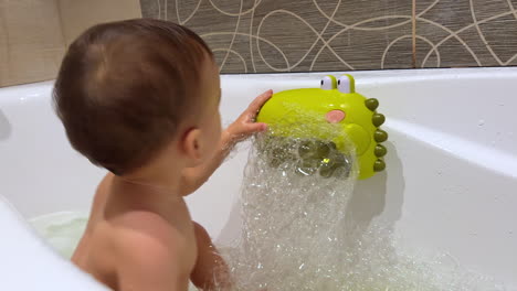 baby in a bubble bath with crocodile toy