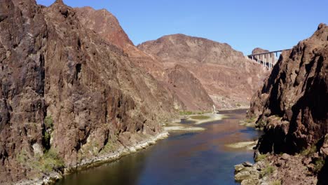 Aerial-view-above-the-river-between-tall-mountain-walls-in-Kingman,-USA---ascending,-drone-shot