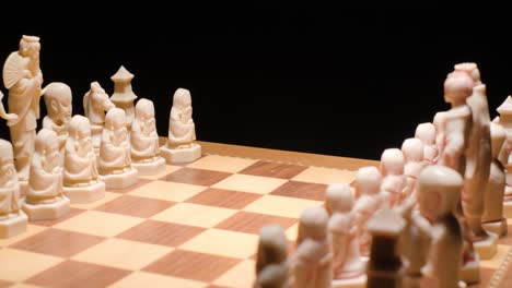 dolly motion through chessboard with pieces in formation, slow motion