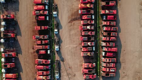 top-down-aerial-of-red-garbage-trucks-in-rows
