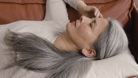 Sick-Middle-Aged-Woman-Having-Headache-While-Lying-On-The-Couch-Covered-At-Home