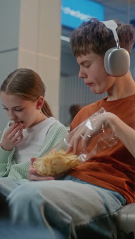 teenagers eating chips at the airport