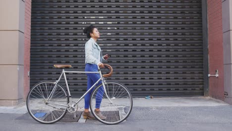 mixed race woman walking next to her bike on the street