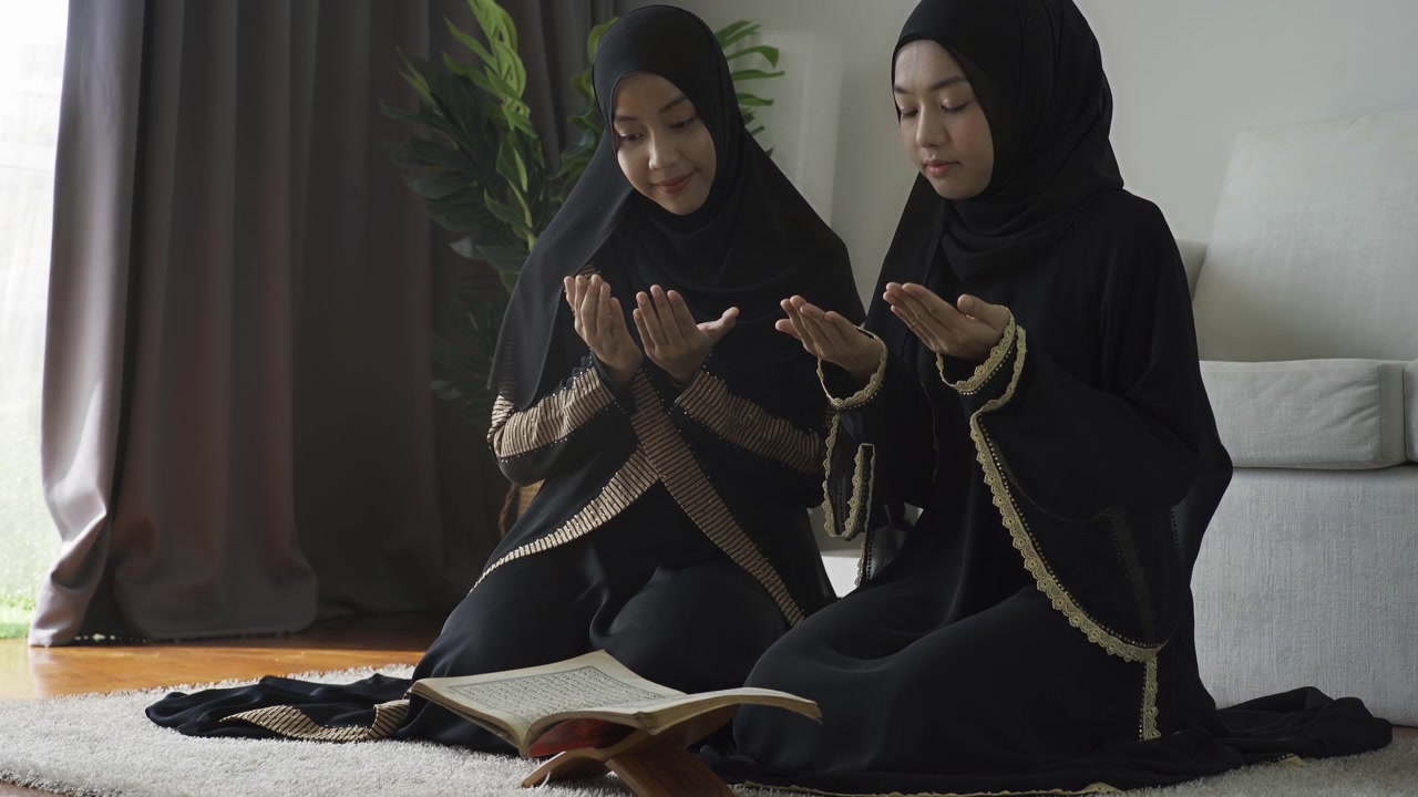 Una donna musulmana asiatica che recita la Salah o il passaggio Salat al-Fatiha del Corano, in un singolo atto di sujud chiamato sajdah o prostrazione, a casa.