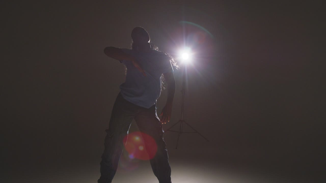 Full Length Studio Shot Of Young Woman Dancer Dancing In Front Of Spotlight