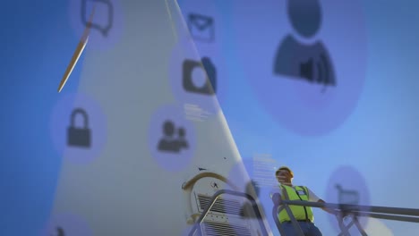 animation of data processing with icons over biracial male worker and wind turbine