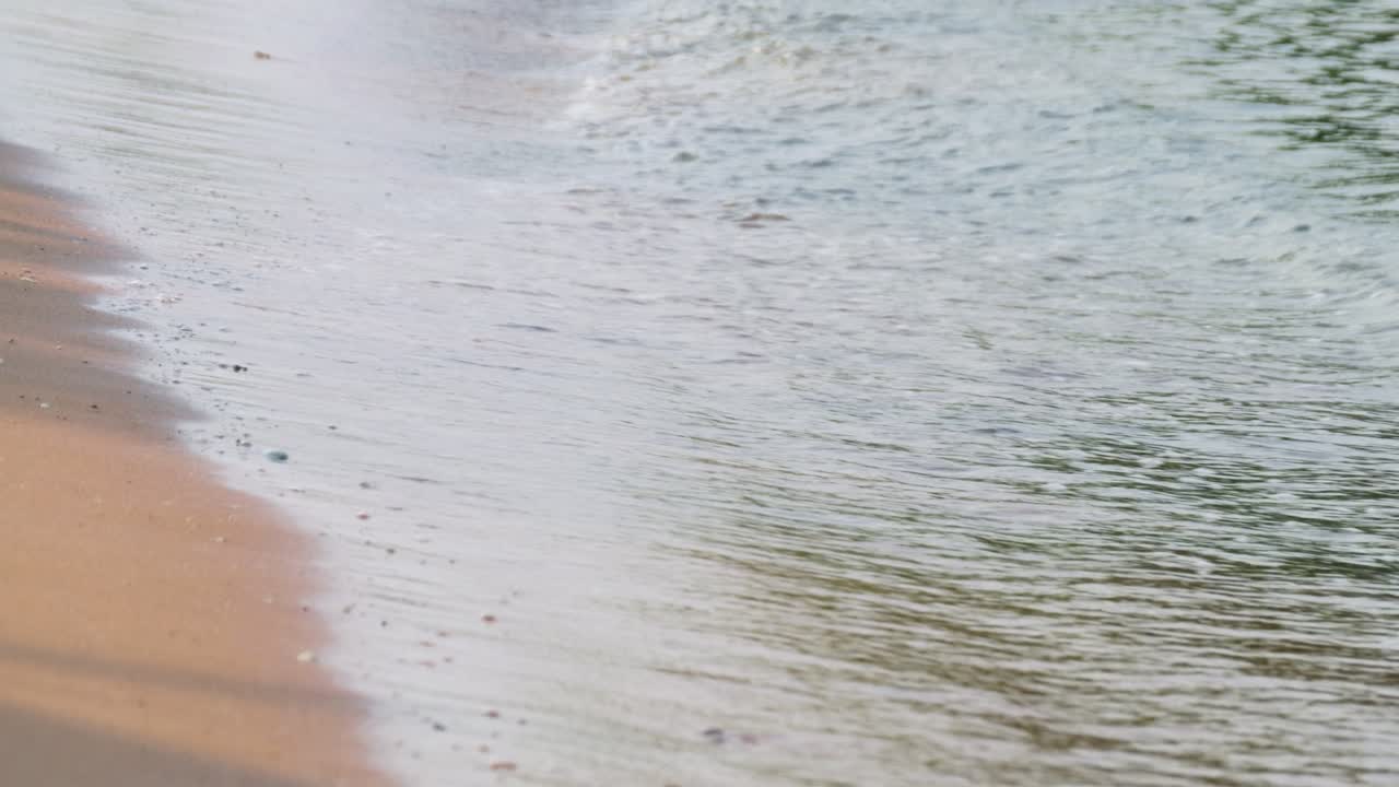 Gentle waves caress a sandy beach creating a serene atmosphere perfect for relaxation.