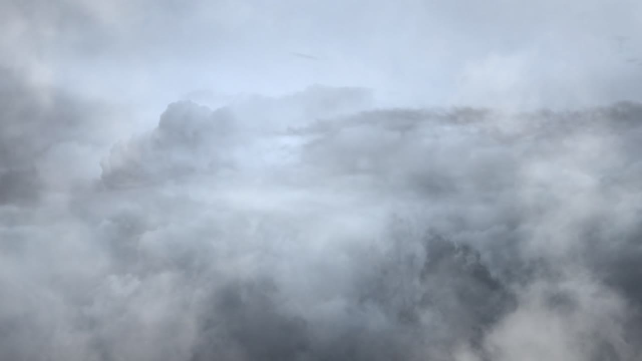 짙은 회색과 뇌우의 적운 구름이 하늘을 가로질러 움직입니다.