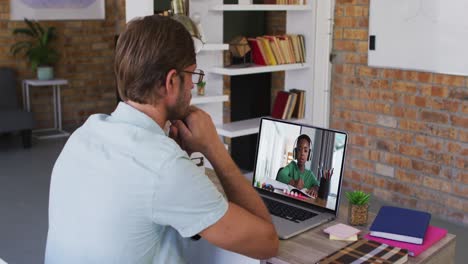 Caucasian-male-teacher-having-a-video-call-on-laptop-with-african-american-boy