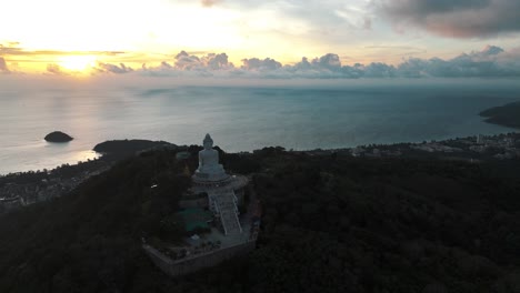 The-Big-Buddha-sculpture-looking-at-sunset-in-Karon-beach,-Phuket-Thailand