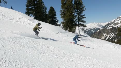 male and female pro skier showing nice downhill ski turns in wonderful snowy mountain landscape in the alps