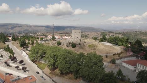 Luftumlauf-Der-Mittelalterlichen-Burg-Guarda-In-Der-Gleichnamigen-Gemeinde-An-Einem-Sonnigen-Tag-Mit-Der-Stadt-Im-Hintergrund---Drohnenaufnahme