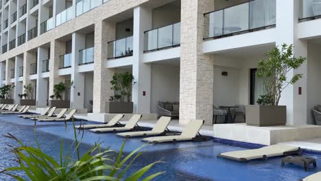 Piscina-Infinita-Con-Tumbonas,-Vacaciones-Tropicales-De-Lujo-Y-Complejo-Vacacional-Con-Todo-Incluido-En-El-Caribe,-Piscina-Moderna-Con-Tumbonas,-Movimiento-De-Alejamiento