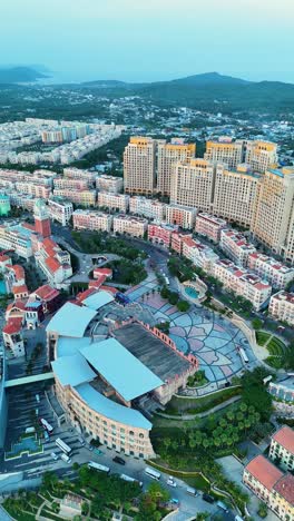 vertical aerial view of phu quoc's sunset town, vietnam. faux italian architecture, vibrant colors, and modern cityscape. ideal for travel or urban development content.