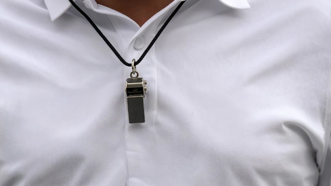 Primo piano di busto maschile che respira, con fischietto oscillante sopra una camicia bianca con colletto e cordino nero.