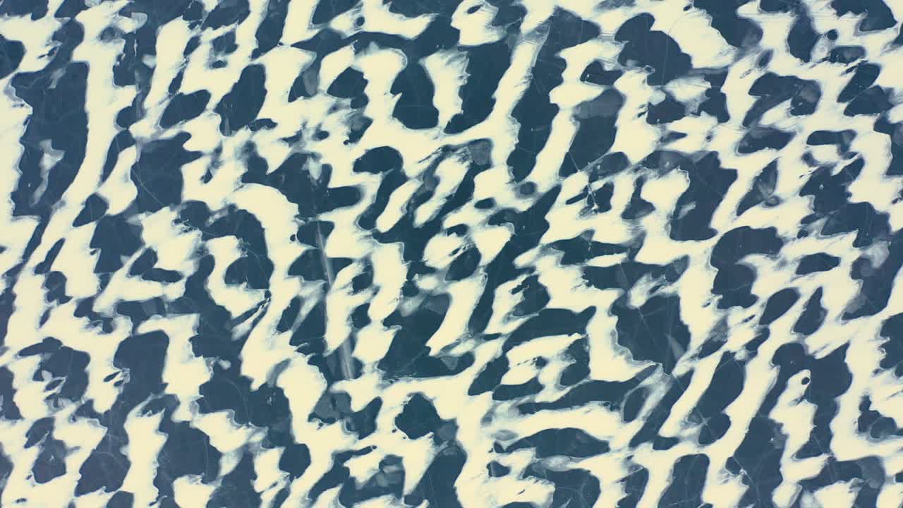 toma aérea de arriba hacia abajo arqueándose sobre los patrones de nieve barridos por el viento en un lago congelado