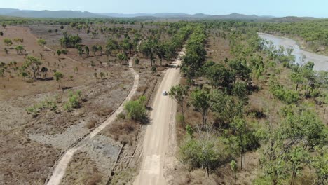 Car-driving-on-rural-road-along-river-banks-in-St-Lawrence,-Clairview-in-Australia