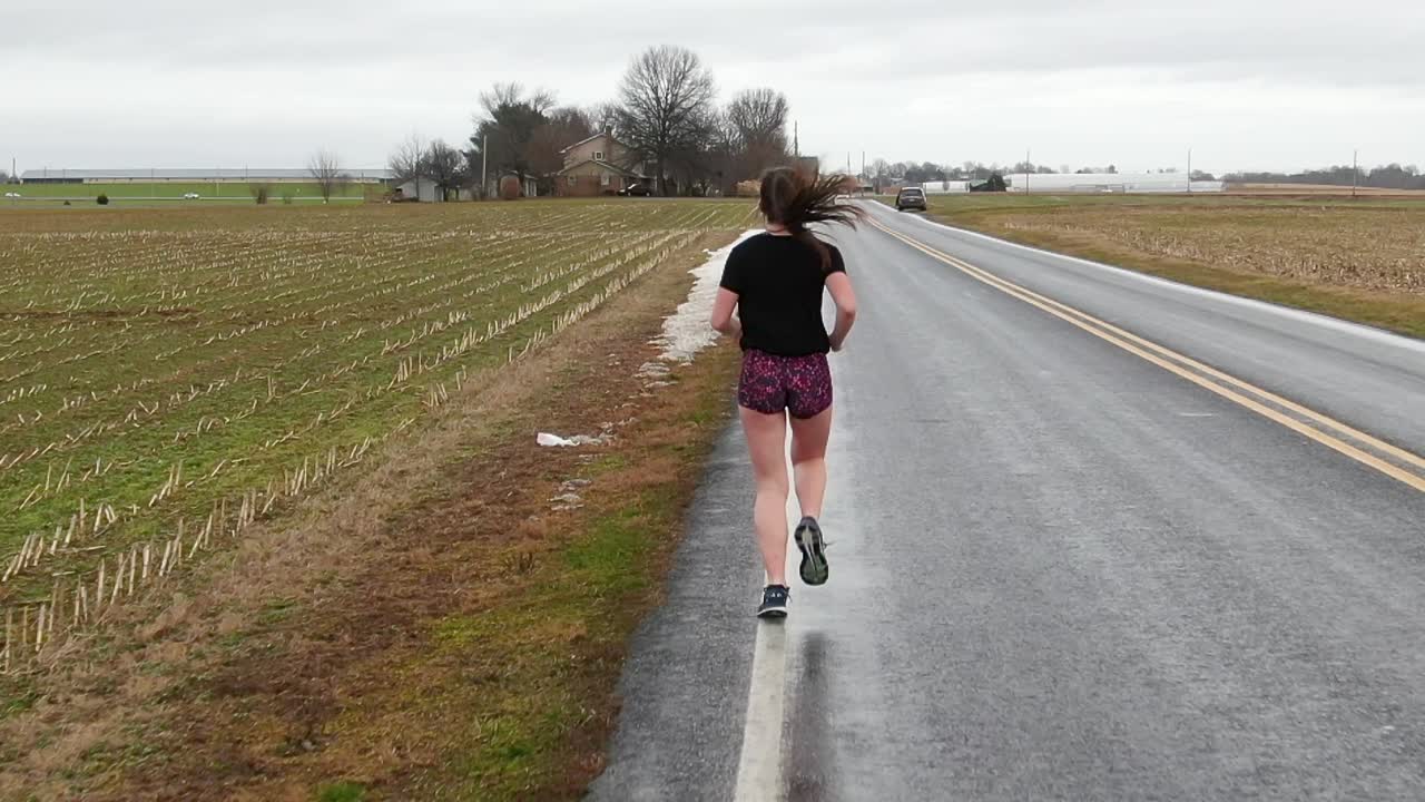 Teenage girl running, hair bounces in slow motion, healthy lifestyle, exercise, physical activity, training, running shoes, female woman caucasian, rear tracking shot