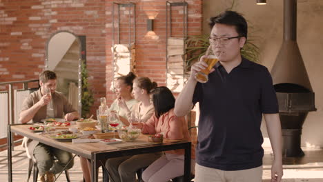 an young woman drinking beer at a dinner party