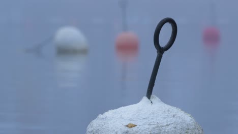 Boyas-De-Señalización-Marina-En-El-Puerto-De-Barcos-Durante-Un-Día-De-Niebla-Fría---Primer-Plano-De-ángulo-Bajo