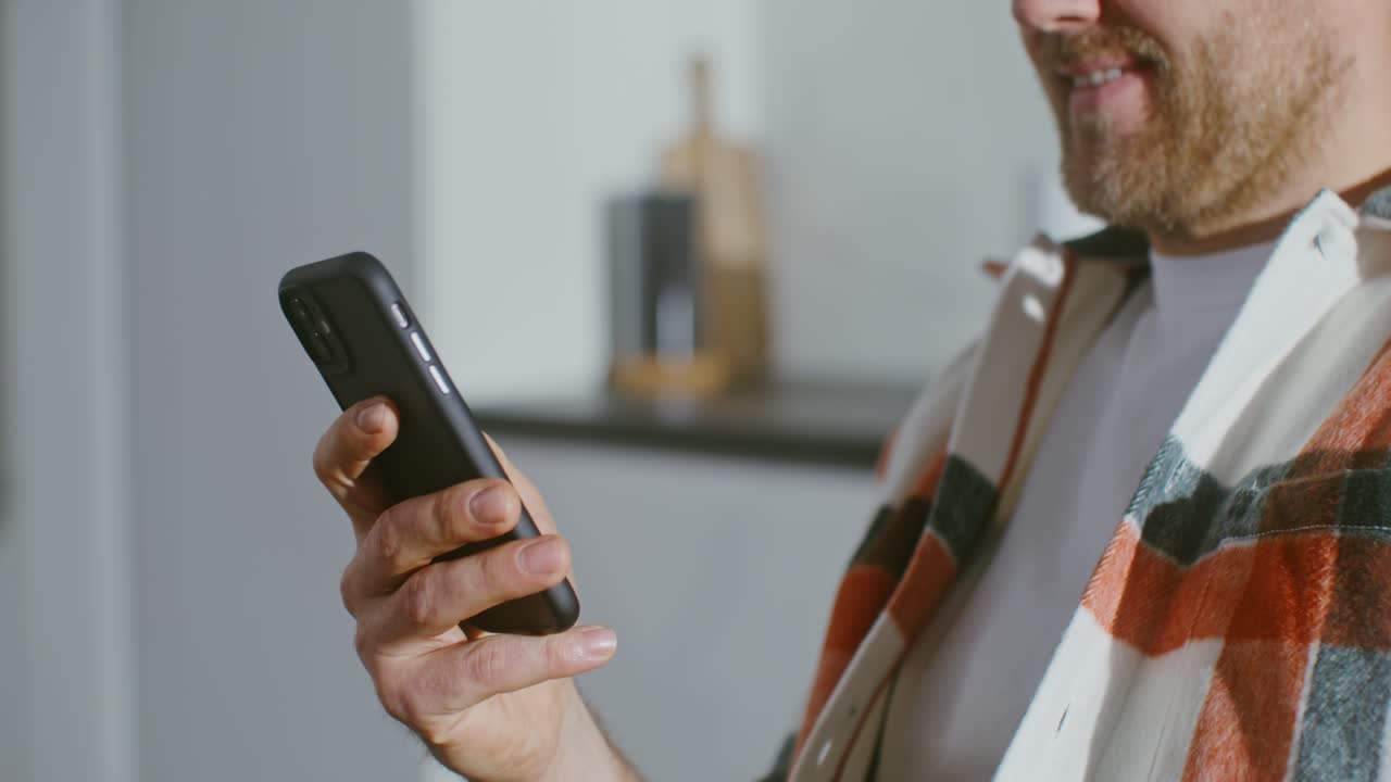 hombre usando teléfono inteligente en la cocina