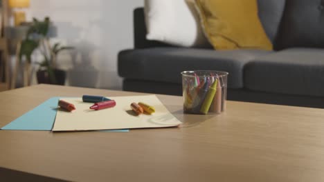 coloured crayons and paper on table at home for child diagnosed with asd