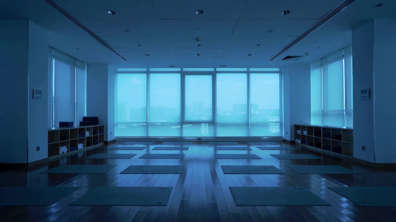 Recording camera capturing empty yoga studio in city, light shifting over mats and props for class