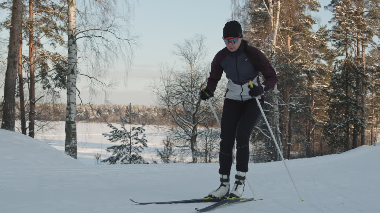 Donna che fa sci di fondo in una foresta invernale