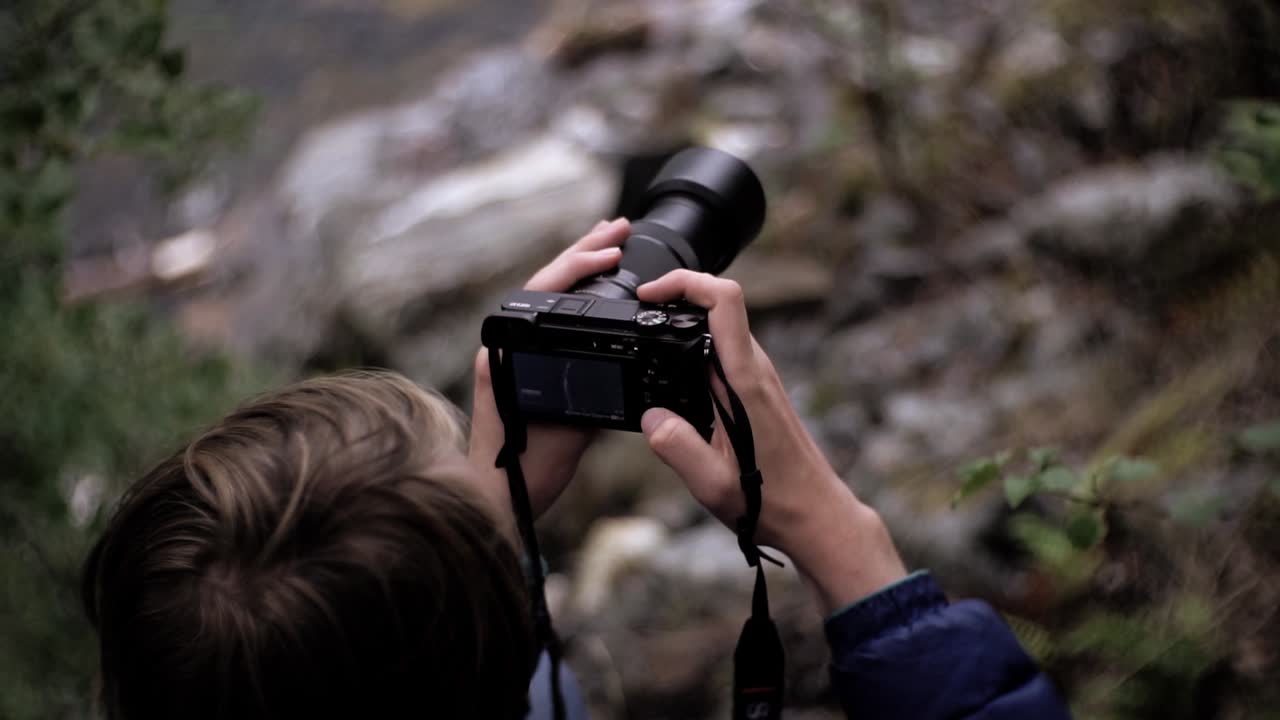 Uomo che maneggia una macchina fotografica in un ambiente naturale, rallentatore, Norvegia, Europa