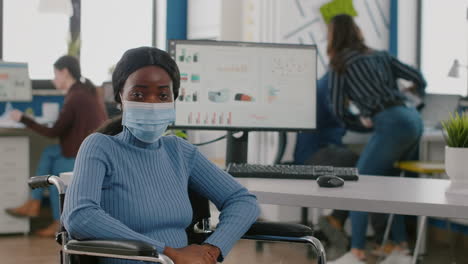 Handicapped-african-employee-looking-at-camera-wearing-protection-mask