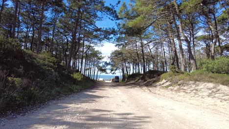 Campervans-parked-on-side-of-dirt-road-near-coastline-of-Nazare,-Portugal