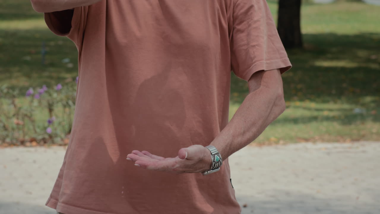Caucasian Man Practicing Circular Moves with Arms Outdoors