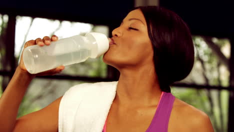 smiling fit woman drinking water