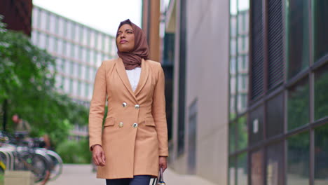 Modern-Muslim-Businesswoman-Wearing-Hijab-With-Business-Suit-Walking-To-Work-Past-Office-Buildings