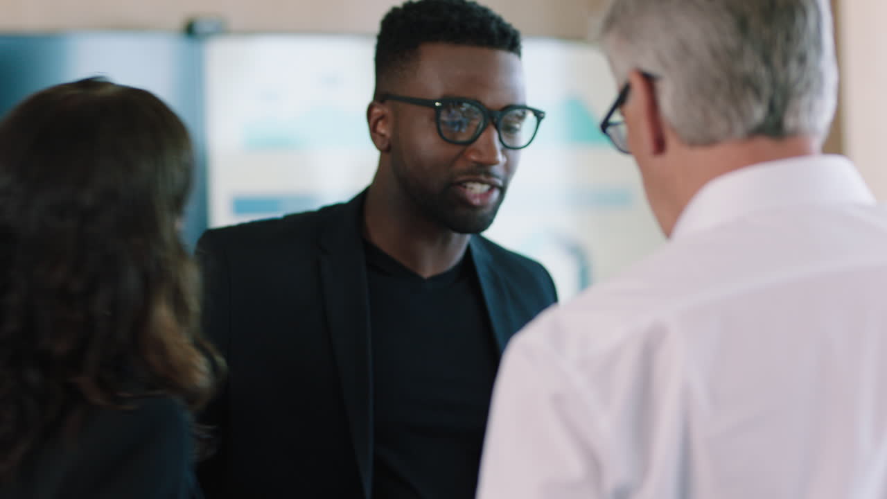 diverse business people meeting shaking hands in boardroom african american businessman preparing for conference chatting with clients shareholders planning partnership deal in corporate office
