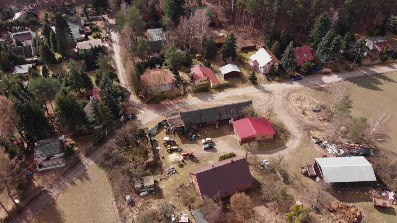 tractores agrícolas fuera del borde de un edificio de madera en el campo rural de la aldea polaca