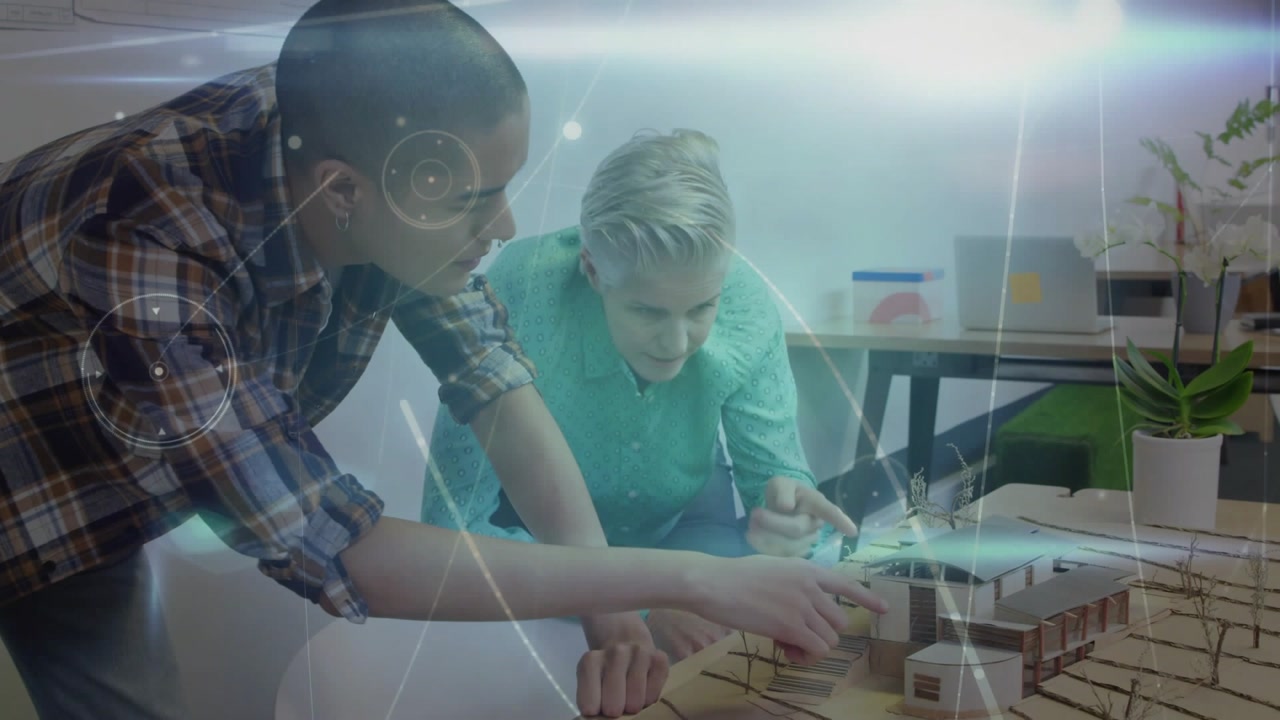 Left architect moving piece causing holographic overlays while colleague adjusting model for review